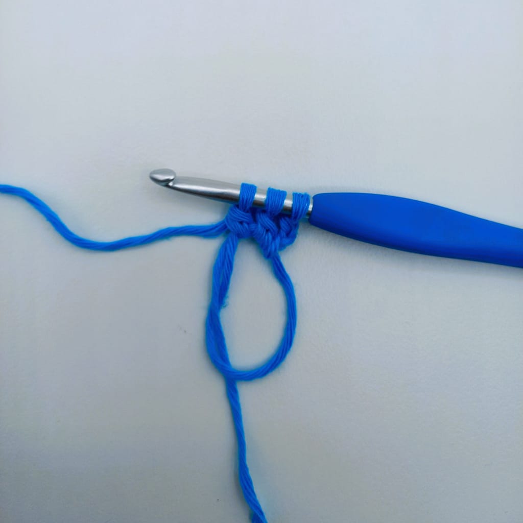 crochet hook with 3 blue stitches on it