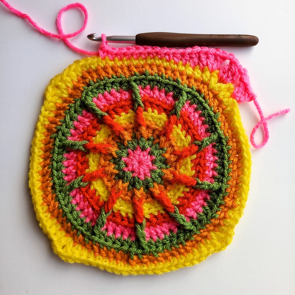 a crocheted circle that is gradually becoming a square as the rounds progress