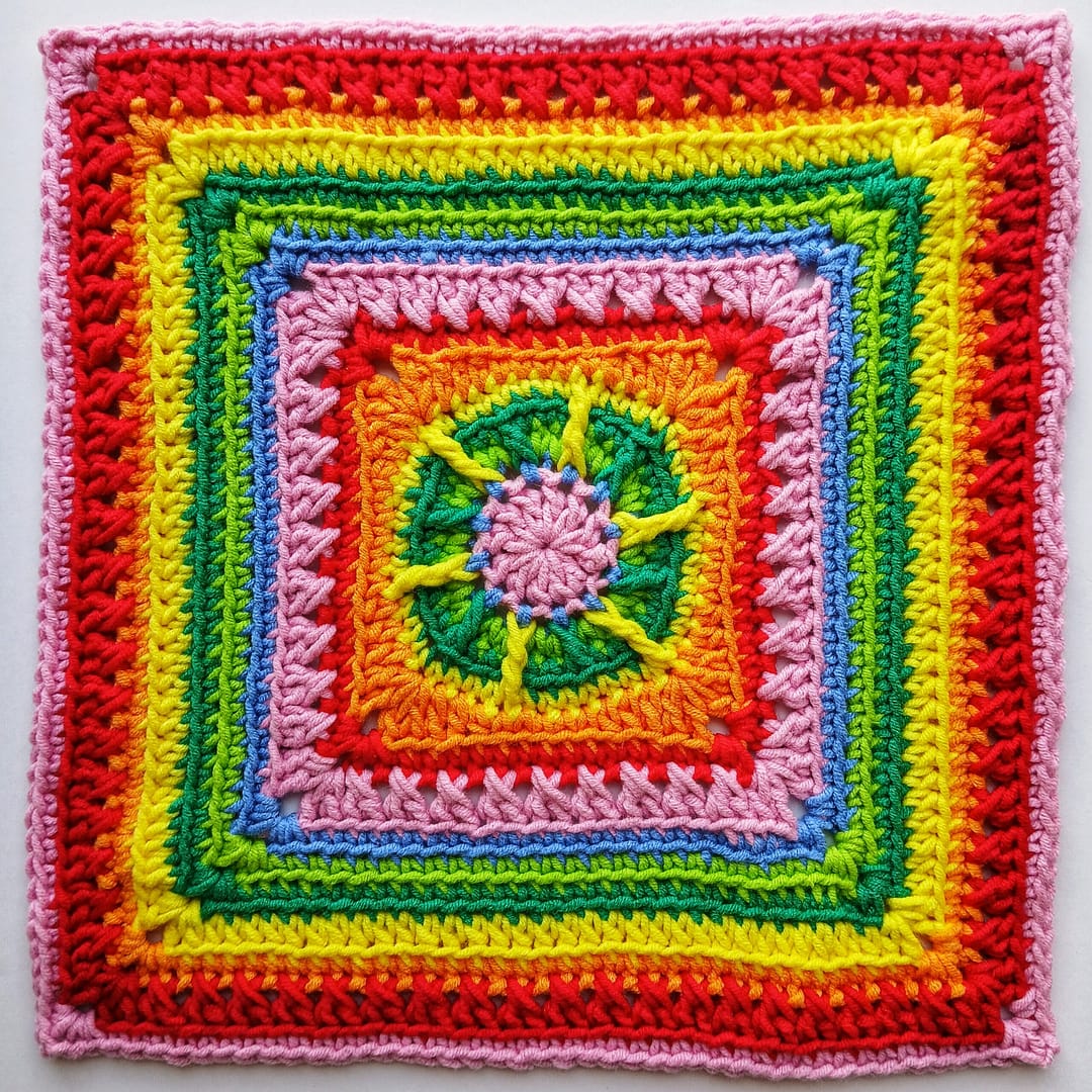 Flat lay of the completed granny square in close up to showcase the textured stitches, made in rainbow colours