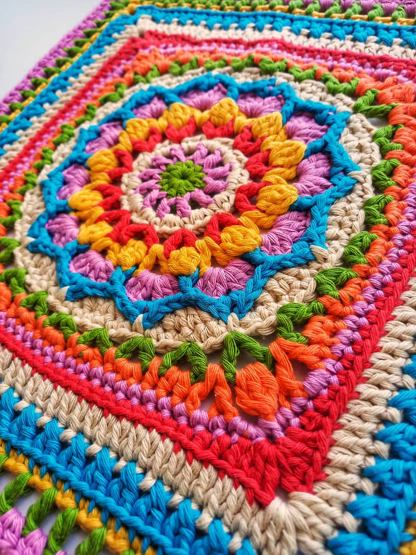 colourful crochet granny square with floral centre